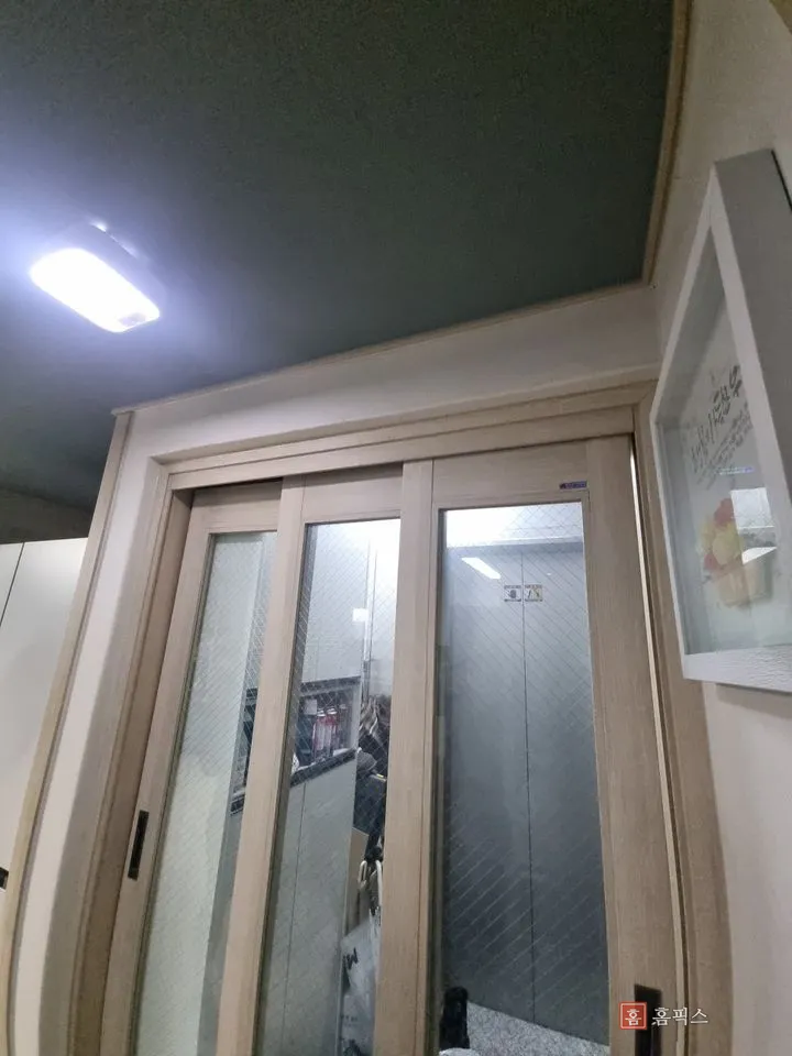 수리를 마치고 제자리에 걸린 현관 중문