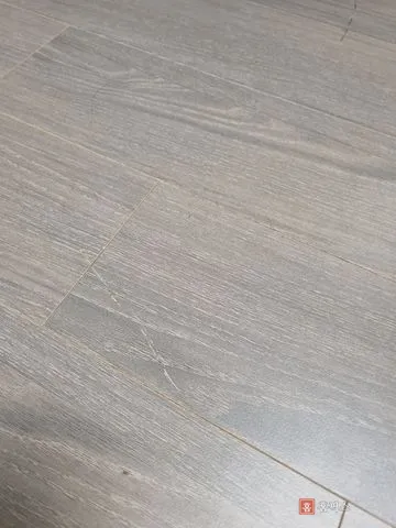 회색 마루 판재에 사선으로 길게 긁힌 자국