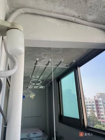 페인트가 벗겨져 콘크리트가 드러난 베란다 천장과 천장형 건조대
