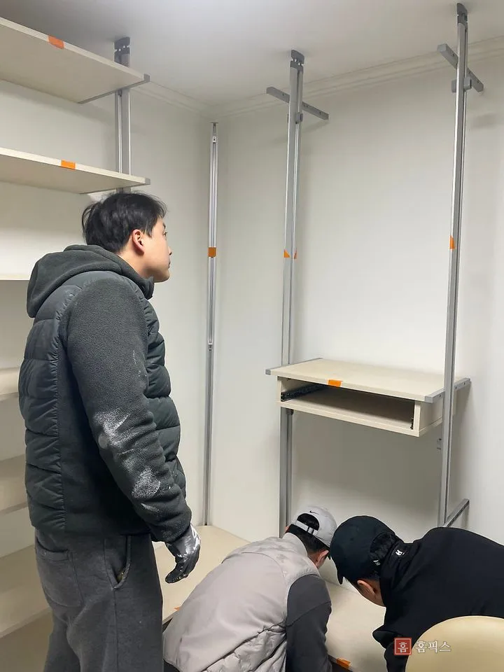 프레임 사이에 서랍 유닛을 끼우며 위치를 확인하는 작업자들