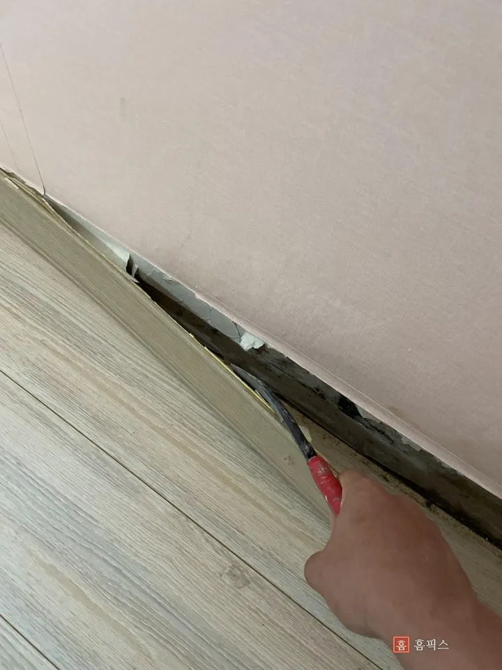 공구로 기존 몰딩을 벽에서 떼어내는 모습