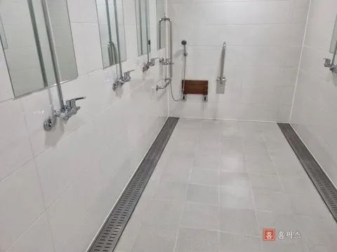 선반 설치 전 샤워 부스, 수전과 거울만 있는 타일 벽면