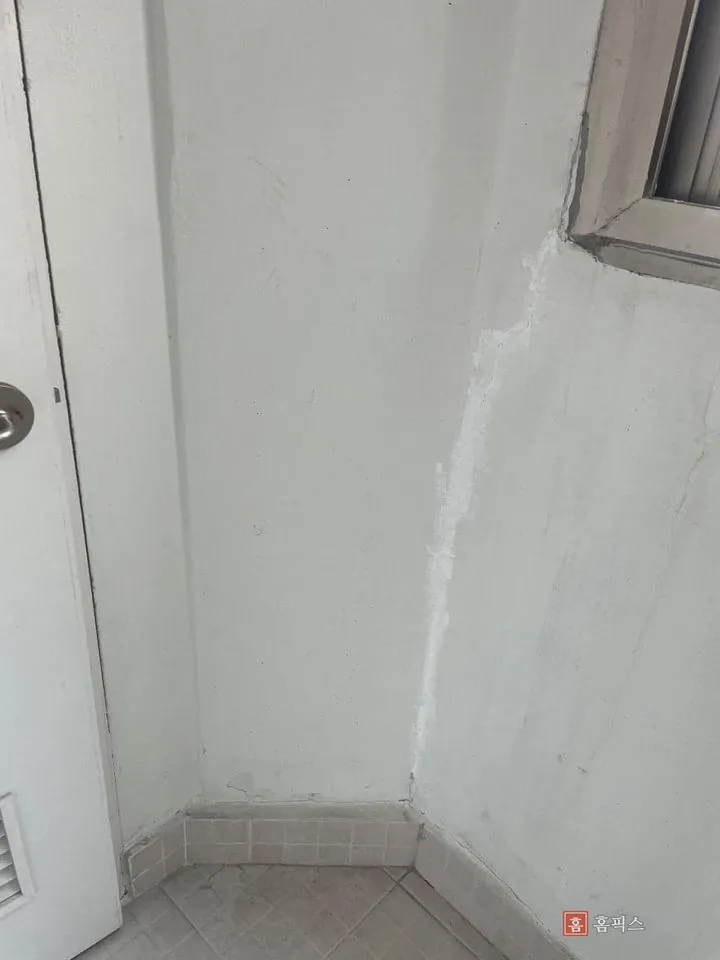 문 옆 모서리 도막이 갈라지고 벗겨진 작업 전 벽면