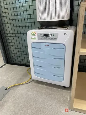 사무실 한쪽에 놓인 제습기와 바닥으로 지나가는 배수 호스