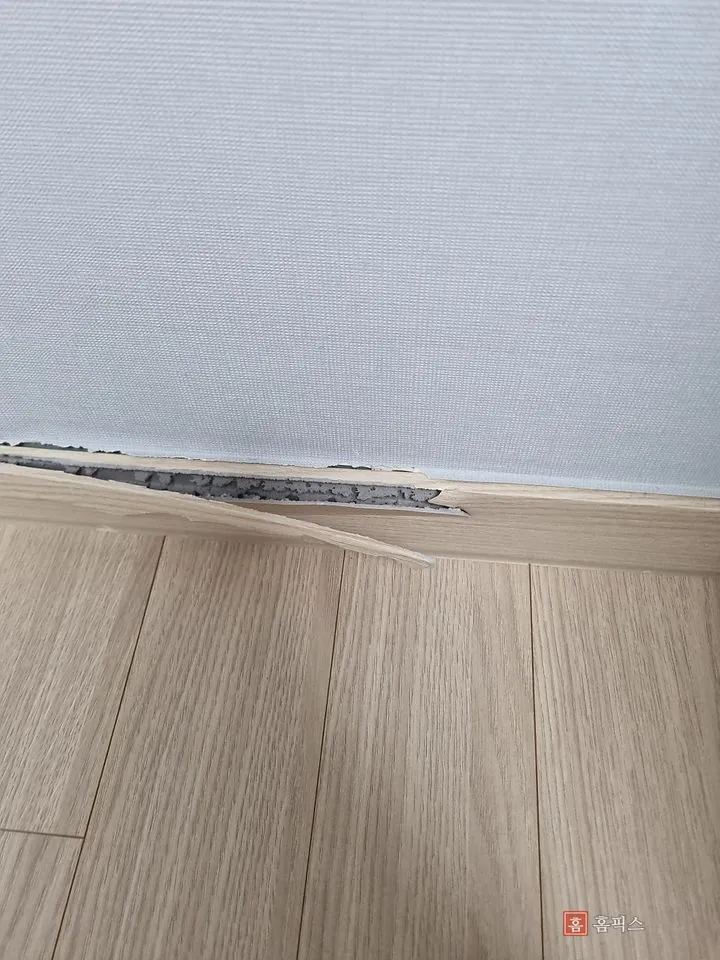 벌어진 틈 사이로 회색 단면이 보이는 깨진 몰딩 근접 모습
