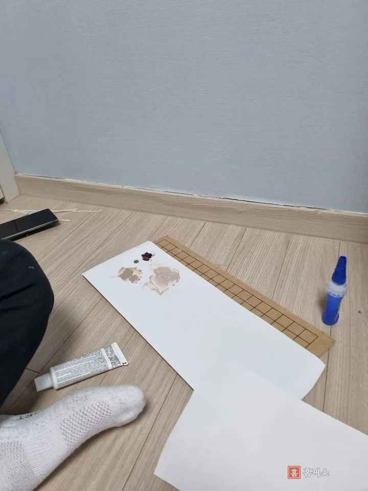 바닥에 종이를 깔고 퍼티 색을 맞추기 위해 조색하는 모습