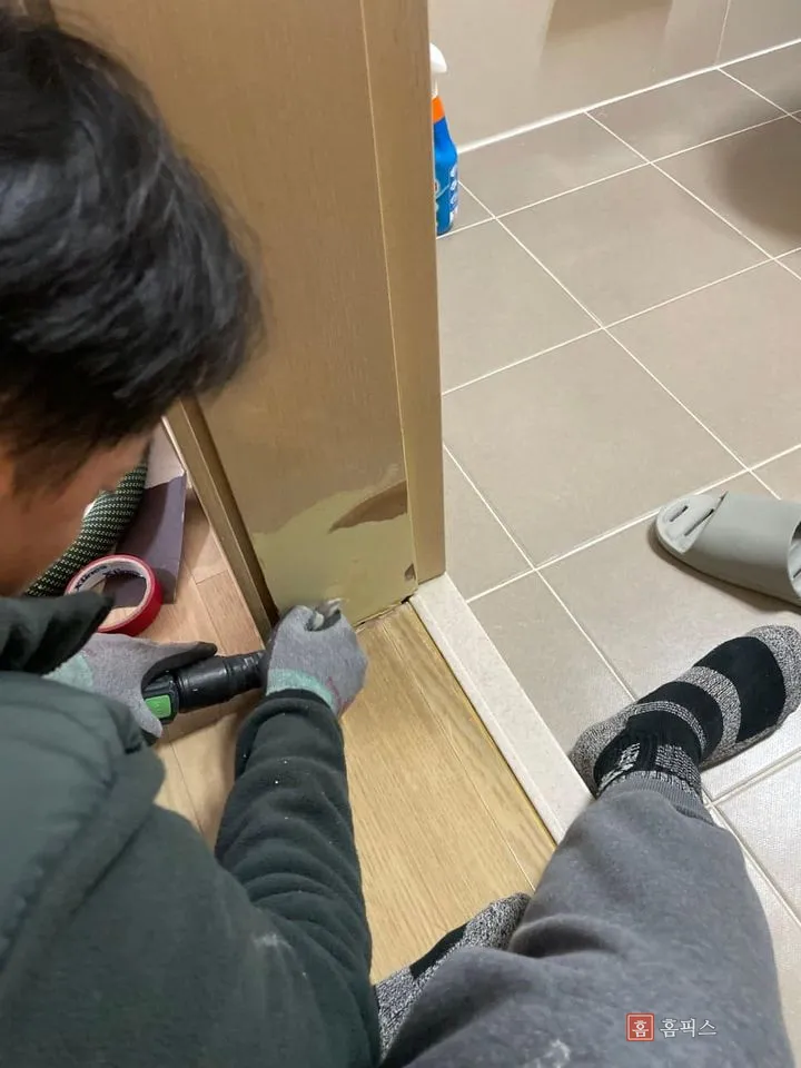 문틀 모서리를 손공구로 다듬으며 면을 확인하는 작업 장면