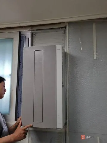 기존 작은방 창틀에서 창문형 에어컨 본체를 탈거하는 모습