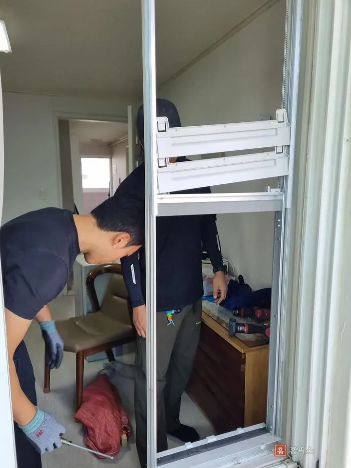 거치대 프레임을 창틀에 세워 고정하는 작업 모습