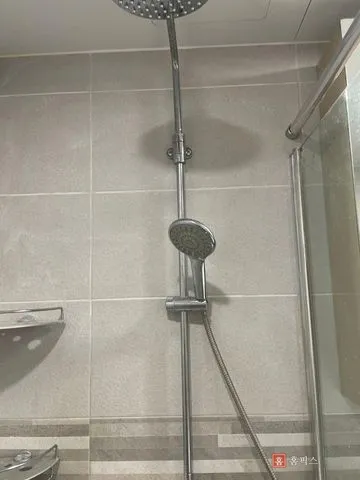 보수를 마치고 샤워기 거치대를 다시 단 욕실 벽면
