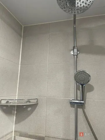 샤워기 거치대가 달린 욕실 벽타일 모서리 부분