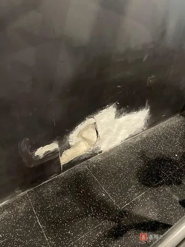 원판에 부딪혀 종이면이 찢기고 속이 드러난 검정 석고보드 벽