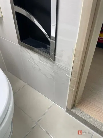 깨진 부분을 투명 테이프로 붙여둔 화장실 벽타일